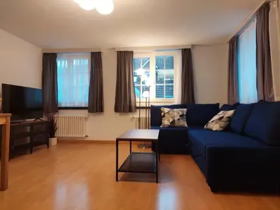 a living room with a blue couch and a table at Global Citizen 7 in St. Gallen