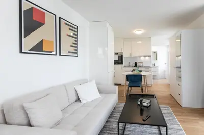 a living room with a white couch and a table at INN JOY Apartments - Roter Platz in St. Gallen