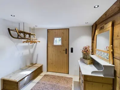 a bathroom with a bench and a mirror and a door at Ferienwohnung Bärli Appenzell in Appenzell