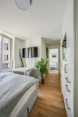 a bedroom with a bed and a desk and a table at HRE Apartments St Gallen City Center in St. Gallen