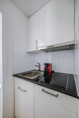 a kitchen with a sink and a red appliance at HRE Apartments St Gallen City Center in St. Gallen