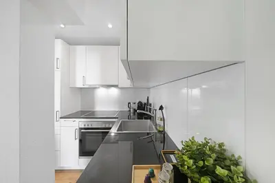 a kitchen with white cabinets and a counter top at Book2Stay - modernes Studio OLMA-Areal in St. Gallen