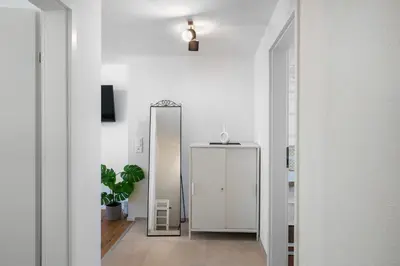 a hallway with a mirror and a white door at book2stay modernes Apartment OLMA-Areal in St. Gallen