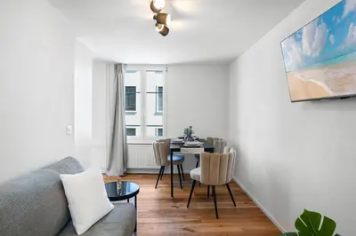 a living room with a table and a dining room at book2stay modernes Apartment OLMA-Areal in St. Gallen