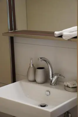 a bathroom sink with a faucet and a mirror at Hotel Kaubad in Appenzell