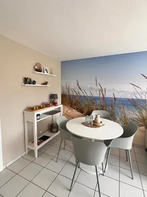 a dining room with a white table and chairs at Ferienwohnung SUN SAND SEA in Horn