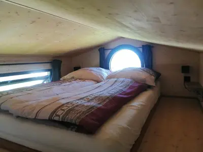 a bed in a small room with a window at Tiny House im Grünen in Sankt Margrethen