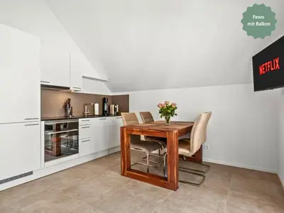 a kitchen with a wooden table and chairs at Ferienhausträume - Dachgeschoss Bodensee Apartment mit großer Dachterrasse in Kreuzlingen