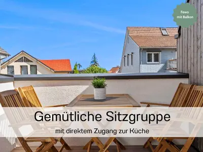 a table and chairs on a balcony with a house at Ferienhausträume - Dachgeschoss Bodensee Apartment mit großer Dachterrasse in Kreuzlingen