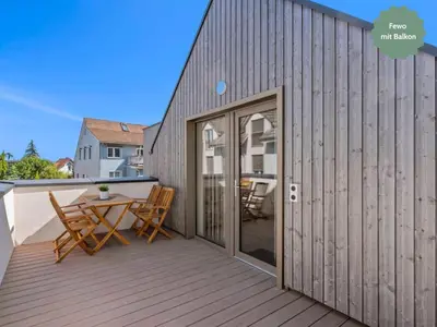 a patio with a table and chairs on a deck at Ferienhausträume - Dachgeschoss Bodensee Apartment mit großer Dachterrasse in Kreuzlingen