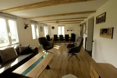 a living room with a couch and a table and chairs at Chalet Wahida- Wellness Oase im Neckertal! in Sankt Peterzell