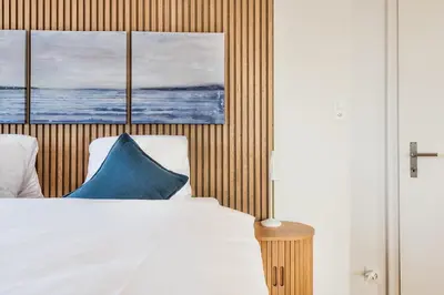 a bedroom with a bed with three paintings on the wall at SOHO PENTHOUSE !Gratis Parken, Free Parking! in Kreuzlingen
