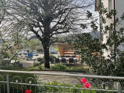 a tree with tables and chairs next to a street at 02 - Gästehaus Erika - Hundwil - Appenzellerland in Hundwil
