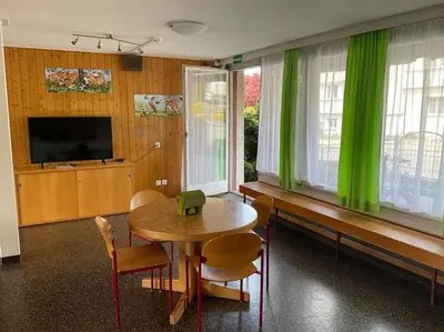a dining room with a table and green curtains at 08 - Gästehaus Erika - Hundwil - Appenzellerland in Hundwil