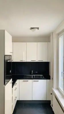 a kitchen with white cabinets and a sink and a window at Klein aber Fein in Rorschach in Rorschach