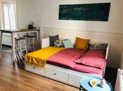 a bed with colorful pillows and a table in a room at Klein aber Fein in Rorschach in Rorschach