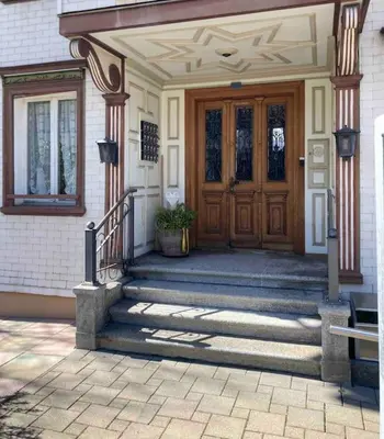 a house with a wooden door and stairs in front at 12 - Gästehaus Erika - Hundwil - Appenzellerland in Hundwil