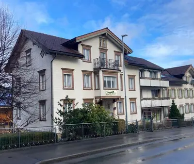 a large white house with a black fence at 14 - Gästehaus Erika - Hundwil - Appenzellerland in Hundwil