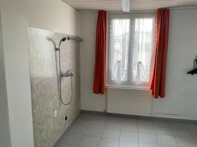 a bathroom with a shower and a window with red curtains at 14 - Gästehaus Erika - Hundwil - Appenzellerland in Hundwil