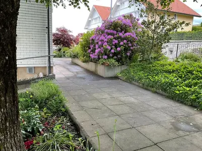 a garden with purple flowers and a sidewalk at 17 - Gästehaus Erika - Hundwil - Appenzellerland in Hundwil