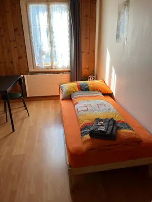 a small bed in a room with a window at 18 - Gästehaus Erika - Hundwil - Appenzellerland in Hundwil