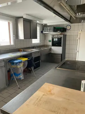 a kitchen with stainless steel counter tops and appliances at 25 - Gästehaus Erika - Hundwil - Appenzellerland in Hundwil