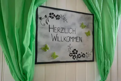 a picture of butterflies on a wall with green curtains at 27 - Gästehaus Erika - Hundwil - Appenzellerland in Hundwil