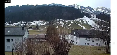 a group of buildings in front of a snow covered mountain at Wildhaus Ferienwohnung in Wildhaus