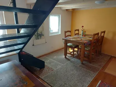 a dining room with a table and chairs and a bunk bed at Bauernhaus Hinterbühle in Wolfhalden