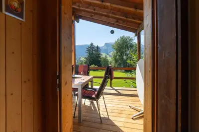 a wooden porch with a table and chairs on a deck at Dorea in Wildhaus