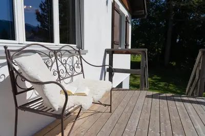 a chair sitting on a porch with a book at Dorea in Wildhaus