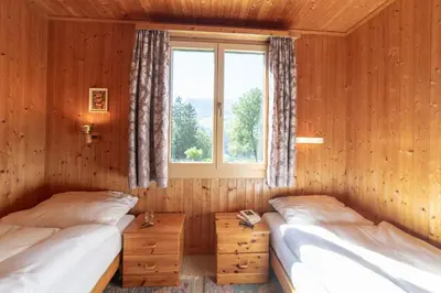 two beds in a room with a window at Dorea in Wildhaus
