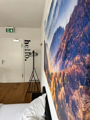 a bedroom with a large painting on the wall at Zentrales Apartment St Gallen an der Olma in St. Gallen