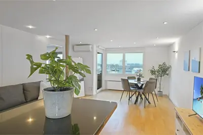 a living room with a table and a potted plant at book2stay - Lakeview Apartment in Romanshorn