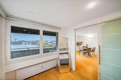 a living room with a large window and a table at book2stay - Lakeview Apartment in Romanshorn