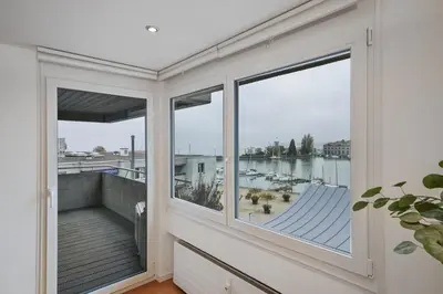 a balcony with windows and a view of the water at book2stay - Lakeview Apartment in Romanshorn