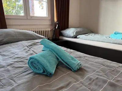 a bed with two beds with towels on it at Altstadt Gästehaus in Arbon