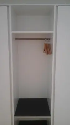 a walk in closet with a white wall at Hotel Flawil in Flawil