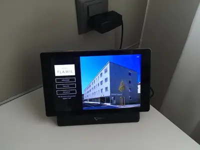 a computer monitor on a table with a building on it at Hotel Flawil in Flawil