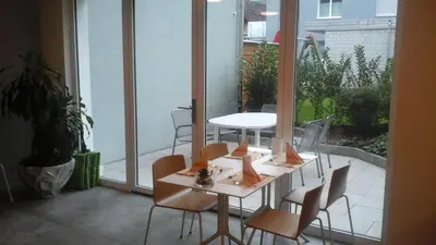 a room with a table and chairs on a balcony at Hotel Flawil in Flawil