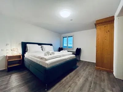 a bedroom with a large bed with a blue bed frame at Private room with Bathroom and Lake View in Guest House in Heiden