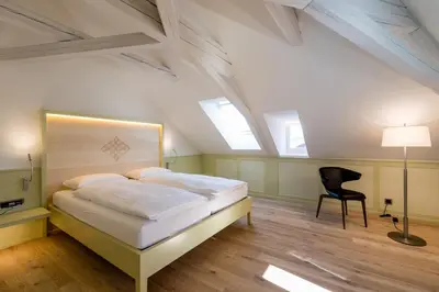 a bedroom with a bed and a chair in it at Hotel Krone Speicher in Speicher