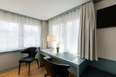 a desk and chairs in a room with windows at Hotel Krone Speicher in Speicher