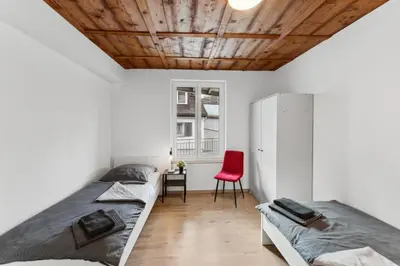 two beds in a room with a red chair at FENUS SGT10 Panoramaview Parking Kitchen in Grabs