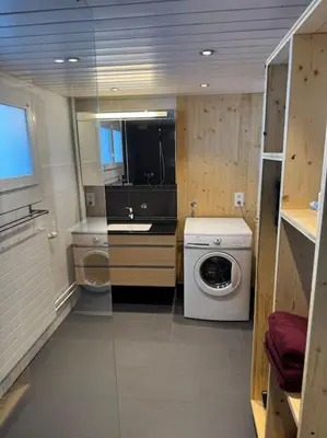 a small bathroom with a washing machine and a sink at Heimelige Wohnung auf der Schwägalp in Urnäsch