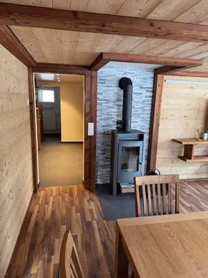 a room with a fireplace and a table and a stove at Heimelige Wohnung auf der Schwägalp in Urnäsch