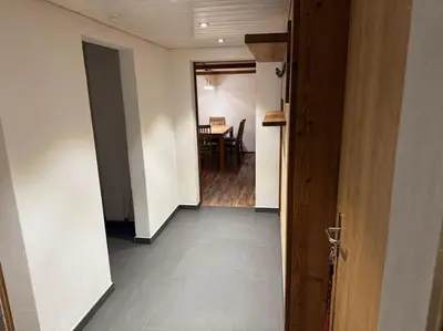 a hallway leading to a dining room with a table at Heimelige Wohnung auf der Schwägalp in Urnäsch