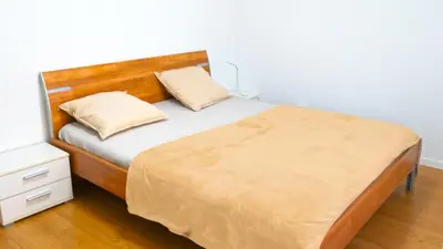 a bedroom with a bed with a wooden headboard at Ninety Apartments in St. Gallen