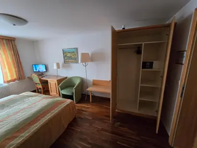 a hotel room with a bed and a desk and a table at Haus Engel Gams in Gams