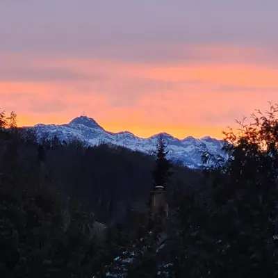a sunset in the mountains with snow covered mountains at Auszeitoase am Wald und Bach in Kradolf